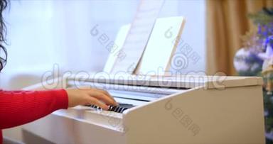 女学生或女学生或专业钢琴家在圣诞假期用漂亮的白色钢琴演奏古典音乐